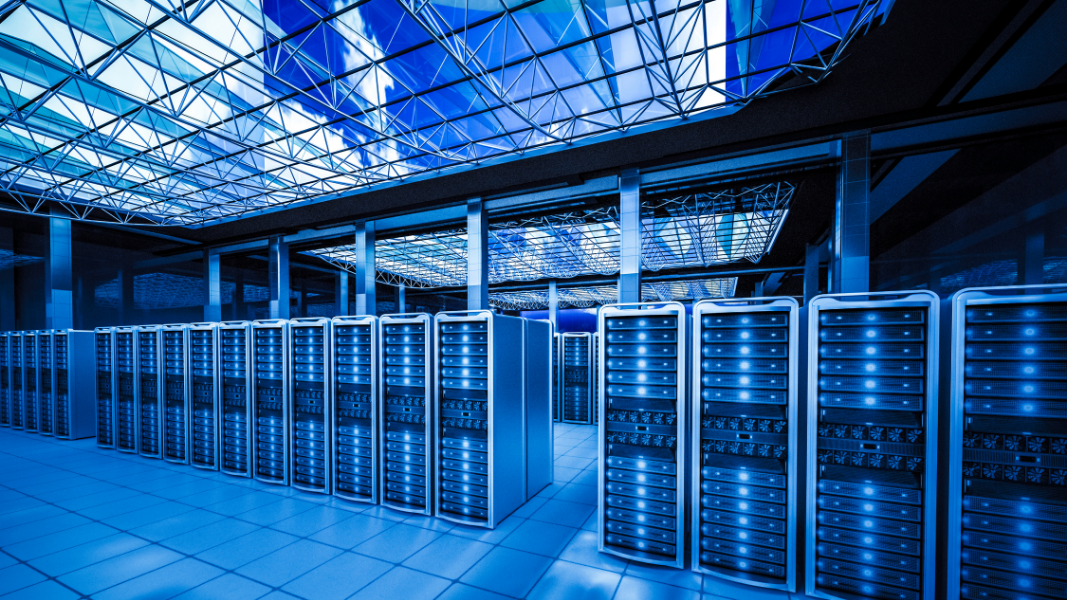 Rows of illuminated server racks in a blue-lit data center hall